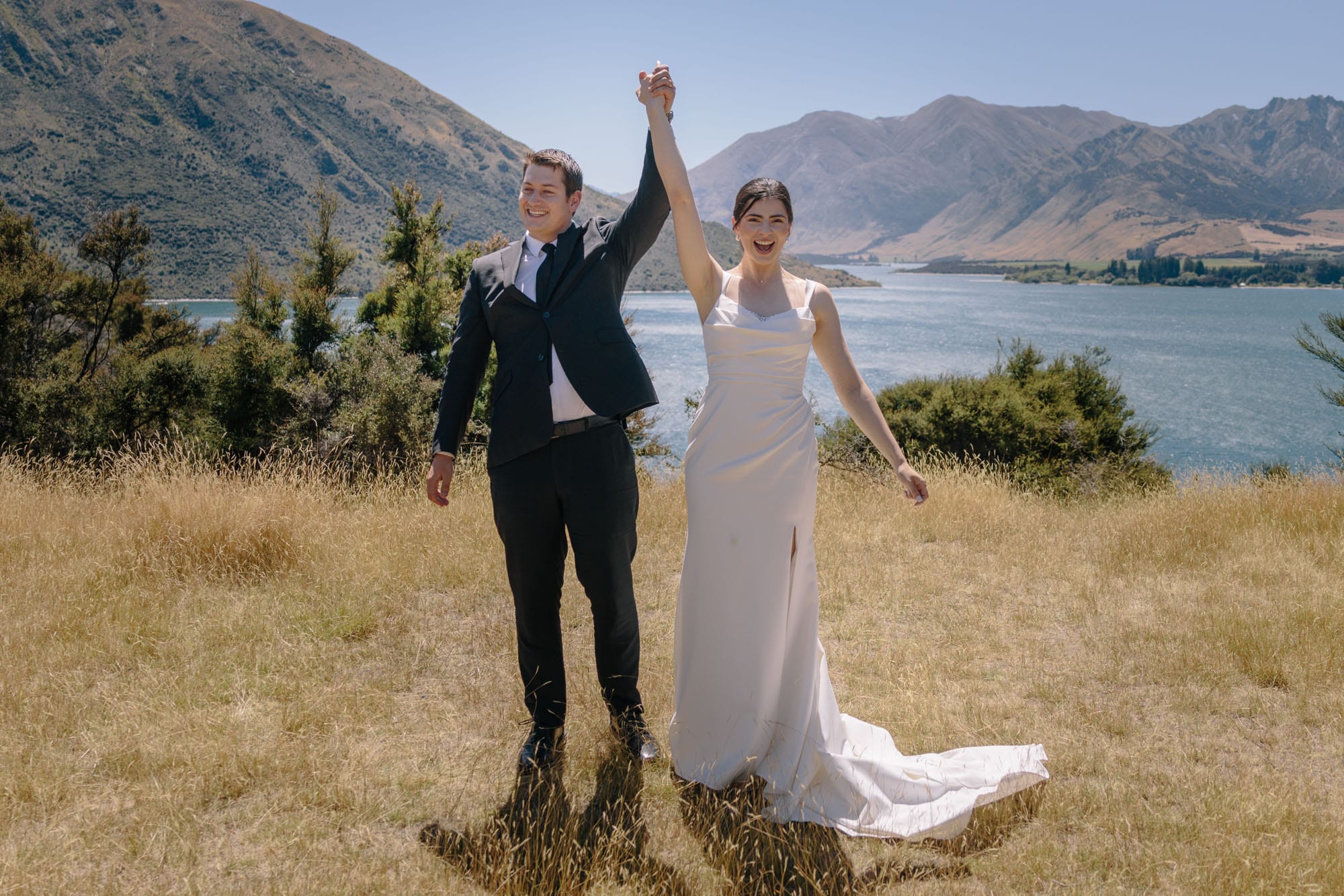 A newly married couple with their arms in the air