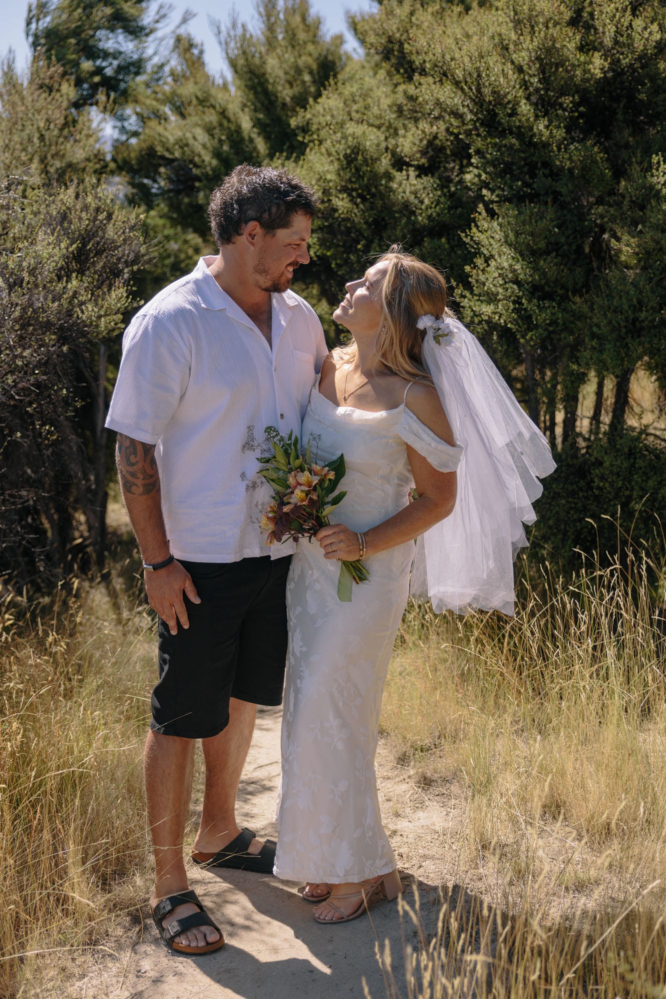 A couple laughing, the groom in shorts and sandals