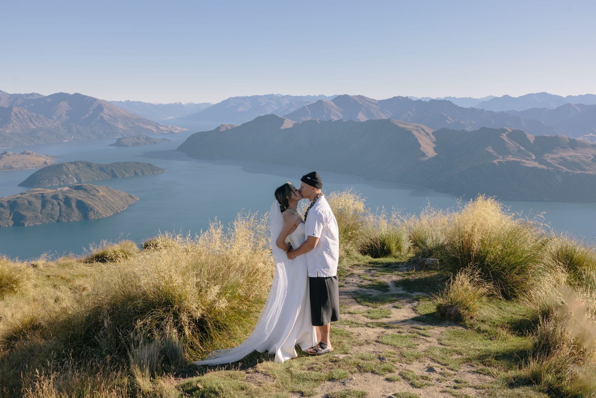 A couple kissing on the ridge above Lake Wānaka