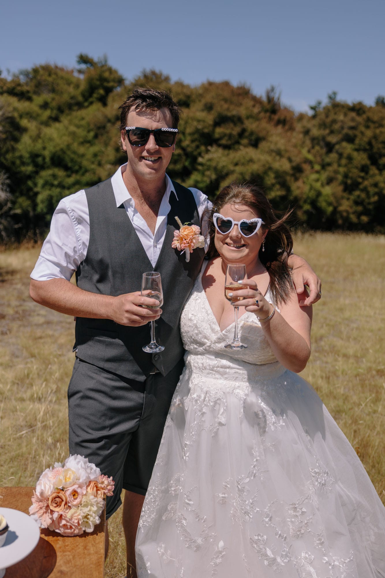 A couple in sunglasses raising their glasses